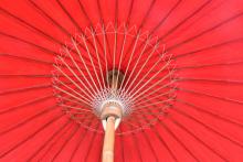 Binnenkant en weefpatroon van een vermiljoenrode thaise bamboe parasol